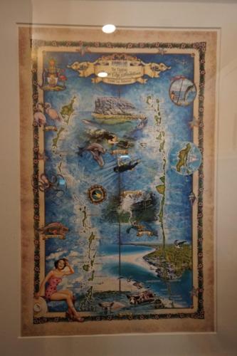 Staniel Cay Vacation Rentals, One bedroom on the water with view of the Staniel Cay Yacht Club. Colorful illustrated map depicting the Bermuda Triangle, featuring dolphins, a ship, and sea motifs surrounded by a decorative border.